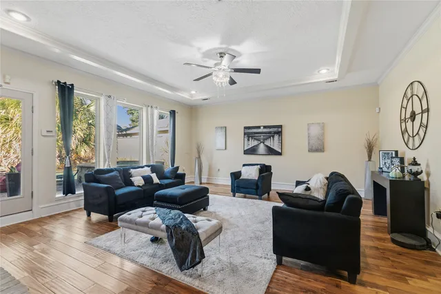 a living room with furniture a large window and a chandelier