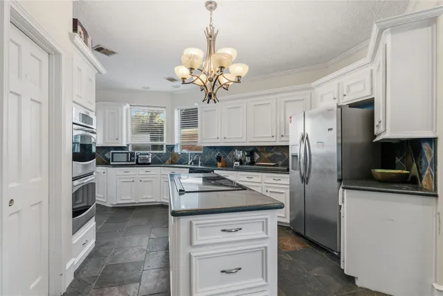 a kitchen with cabinets stainless steel appliances and a window