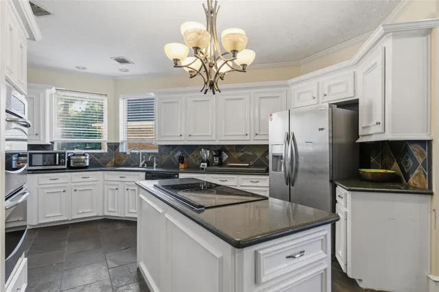 a kitchen with a center island white cabinets and stainless steel appliances