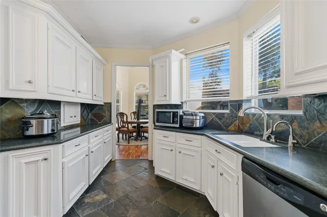 a kitchen with stainless steel appliances granite countertop a sink a stove and cabinets