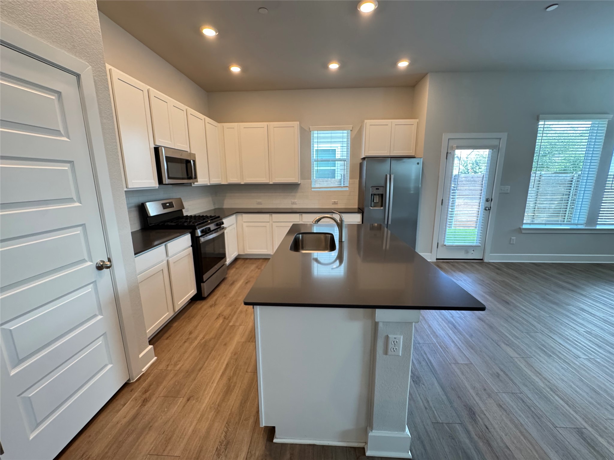 3000 Chisholm Trail Road, Unit 91 Round Rock, TX 78681 - Photo 2 of 27 A well-appointed kitchen showcasing a central island, recessed lighting, and rich wood flooring.