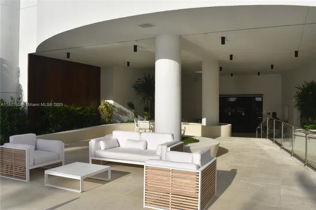 a view of a patio with a table chairs and a floor to ceiling window