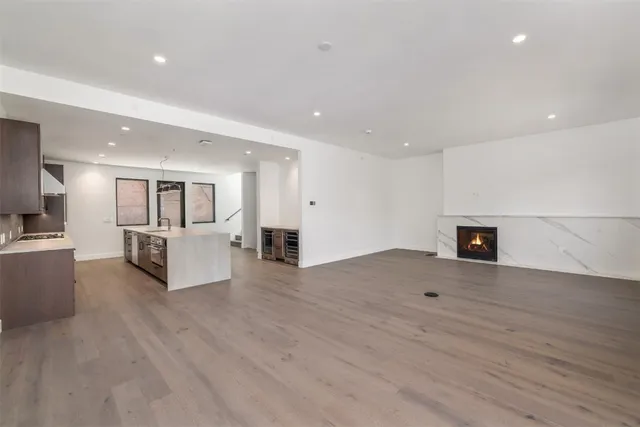 a large kitchen with stainless steel appliances a large counter top a stove and a sink