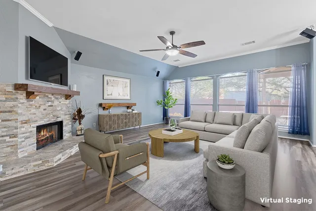 a living room with furniture a flat screen tv and a fireplace