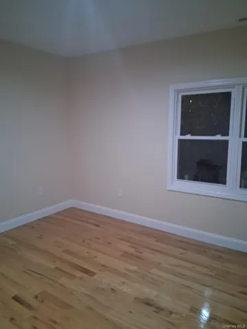 a view of empty room with wooden floor and fireplace