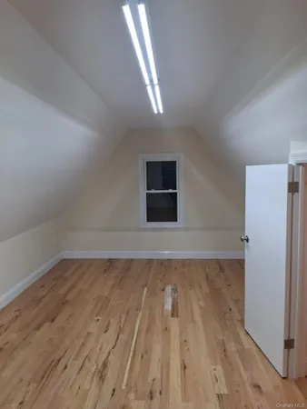 a view of a hallway with wooden floor and a window