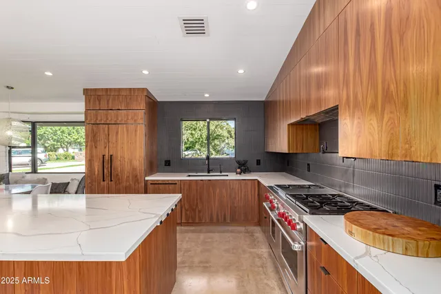 a large kitchen with kitchen island a large window in it