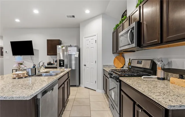 a kitchen with stainless steel appliances granite countertop a sink stove and refrigerator