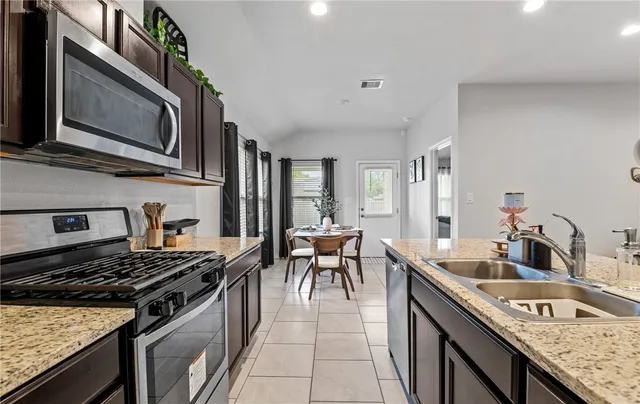 a kitchen with stainless steel appliances granite countertop a stove and a sink