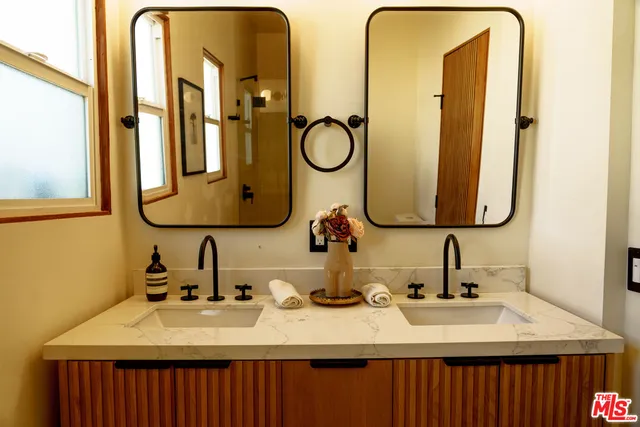 a bathroom with a double vanity sink and a mirror