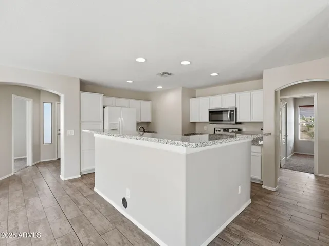 a kitchen with stainless steel appliances granite countertop a sink and a refrigerator