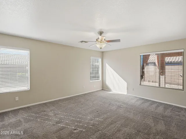 a view of a big room with wooden floor and windows