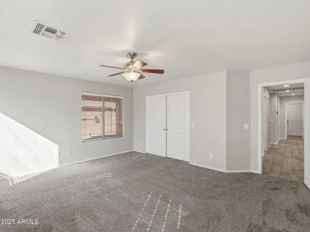 a view of an empty room with a ceiling fan