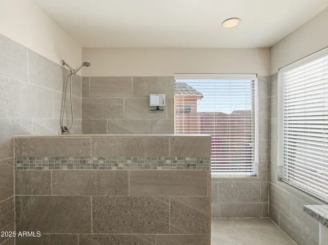 a bathroom with a granite countertop double vanity and a mirror