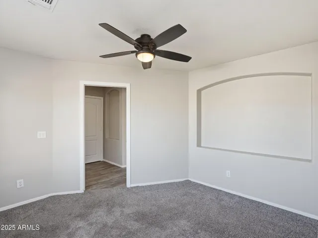 an empty room with a ceiling fan and a window