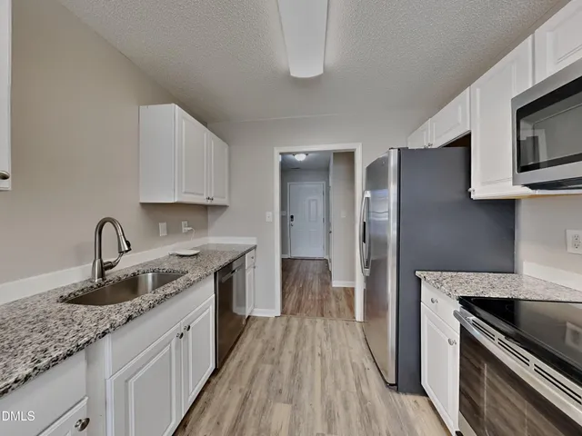 a kitchen with a sink stove and refrigerator