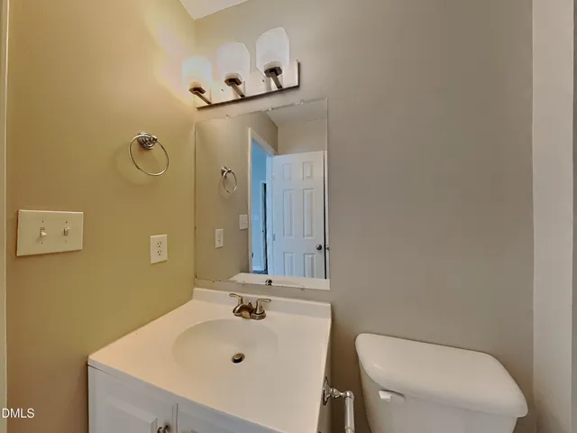 a bathroom with a sink a toilet and mirror