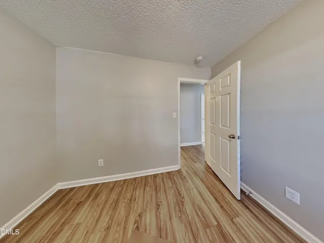 a view of a small space with wooden floor and a window