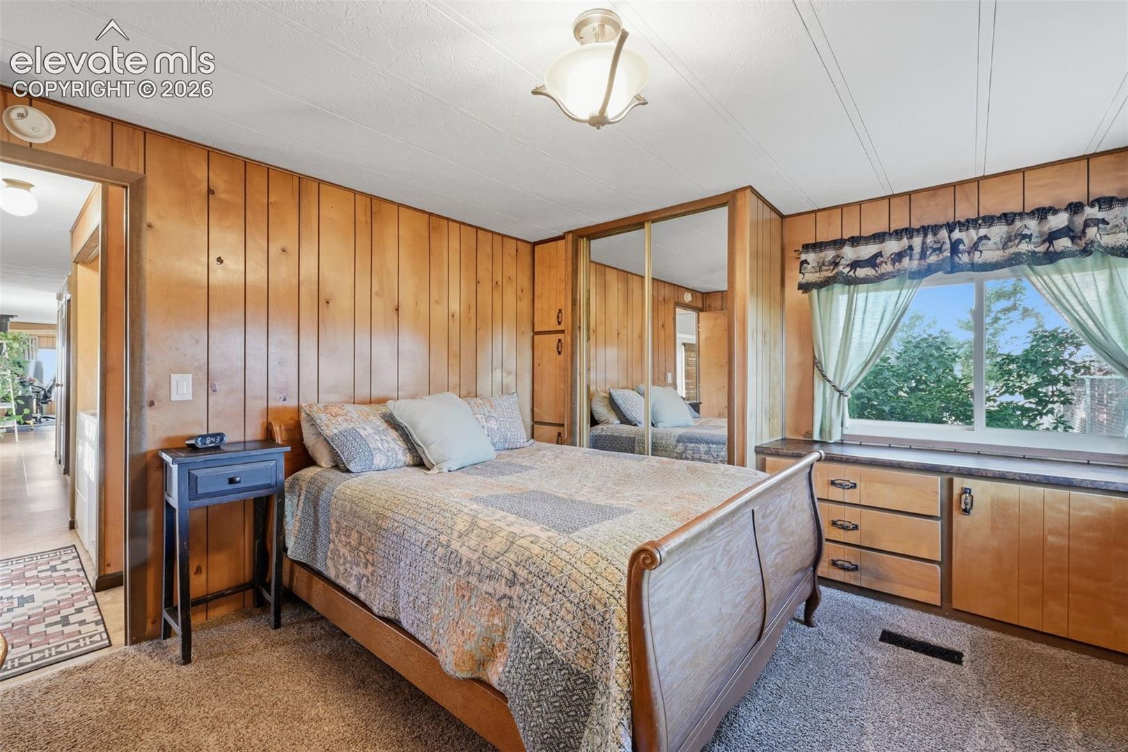 6015 West Condor Road Peyton, CO 80831 - Photo 28 of 50 Wood-paneled walls and a window with outdoor scenery