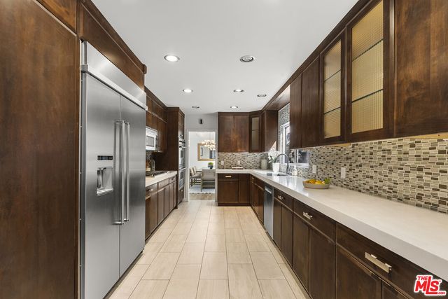 a large kitchen with stainless steel appliances kitchen island granite countertop a sink and cabinets
