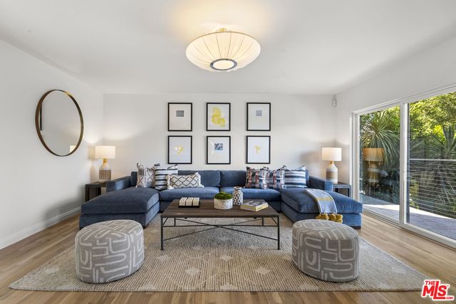 a living room with furniture a table and a large window