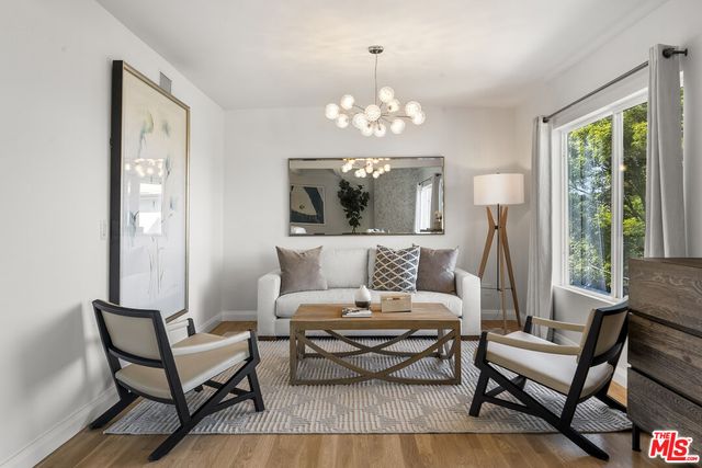 a living room with furniture chandelier and a window