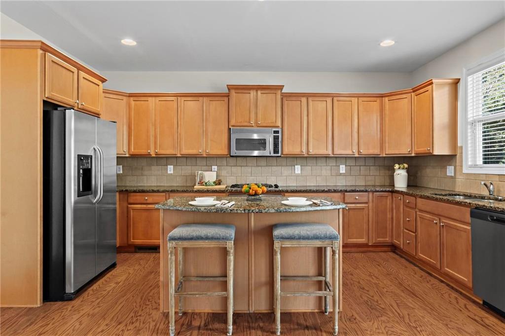 4250 Granby Circle Cumming, GA 30041 - Photo 12 of 37 a kitchen with stainless steel appliances granite countertop a stove a sink refrigerator and a microwave
