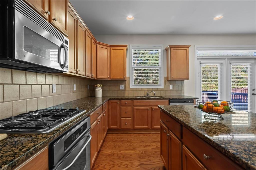4250 Granby Circle Cumming, GA 30041 - Photo 16 of 37 a kitchen with stainless steel appliances granite countertop a stove and a sink