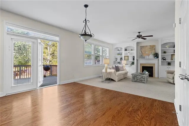 a view of a livingroom with furniture a fireplace and windows