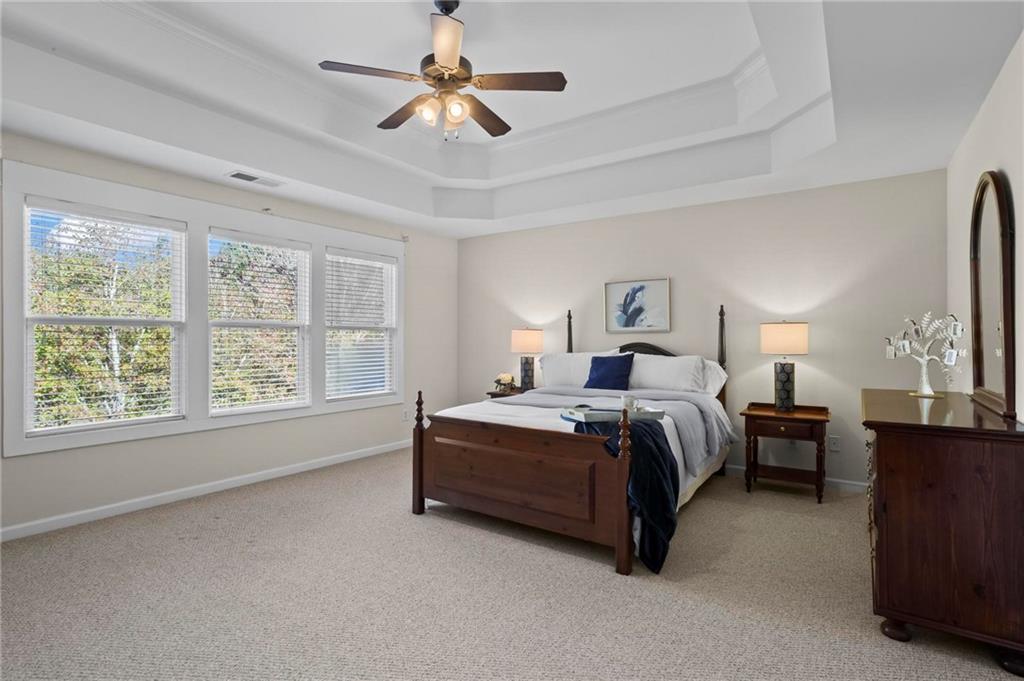 4250 Granby Circle Cumming, GA 30041 - Photo 20 of 37 a spacious bedroom with a bed a chandelier and a large window