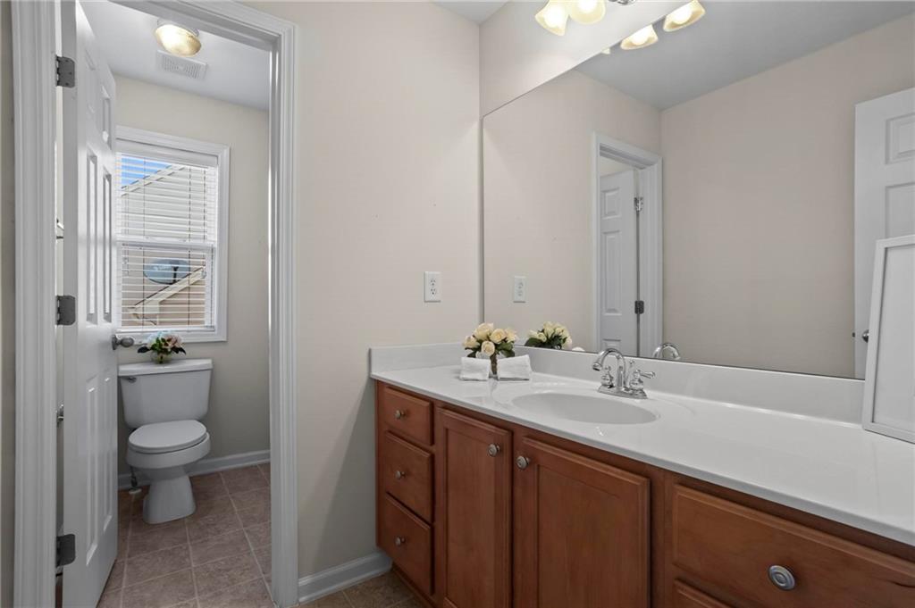 4250 Granby Circle Cumming, GA 30041 - Photo 30 of 37 a bathroom with a toilet a sink and mirror
