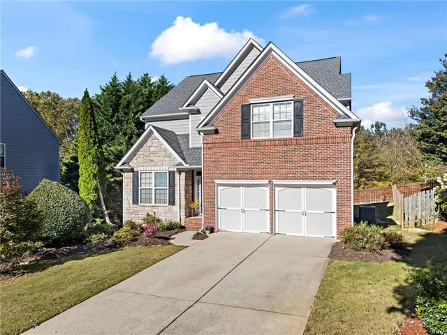 a front view of a house with a yard and potted plants