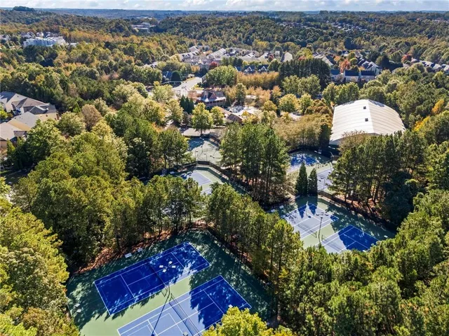 an aerial view of residential houses with outdoor space and trees