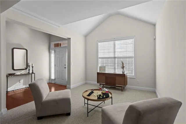 a living room with furniture a flat screen tv and a window