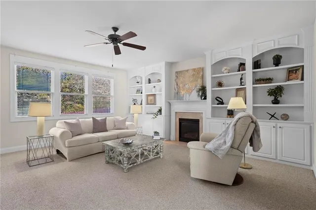 a living room with furniture fireplace and a large window