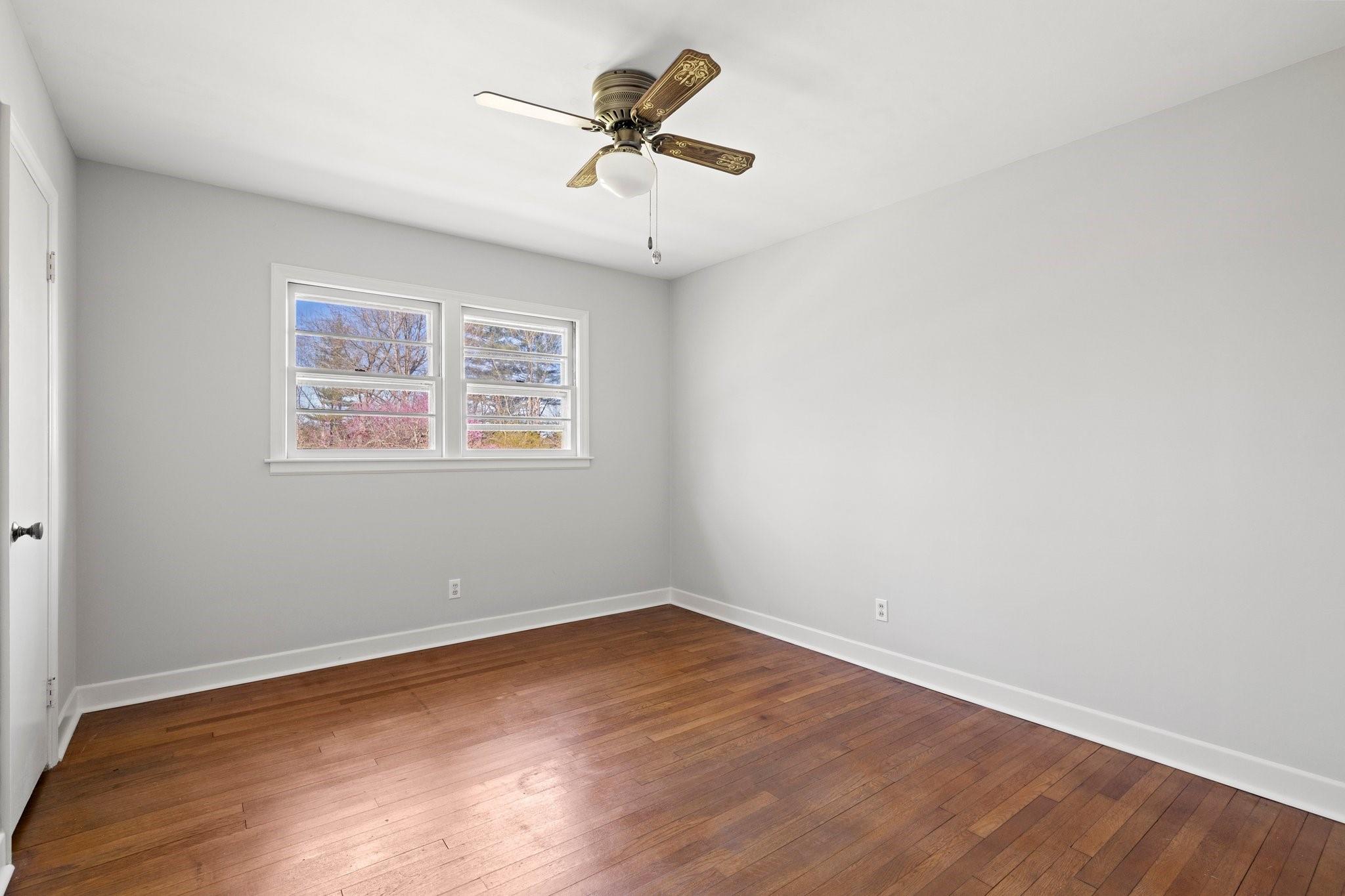 480 Loop Road Hendersonville, NC 28792 - Photo 15 of 26 an empty room with wooden floor and ceiling fan