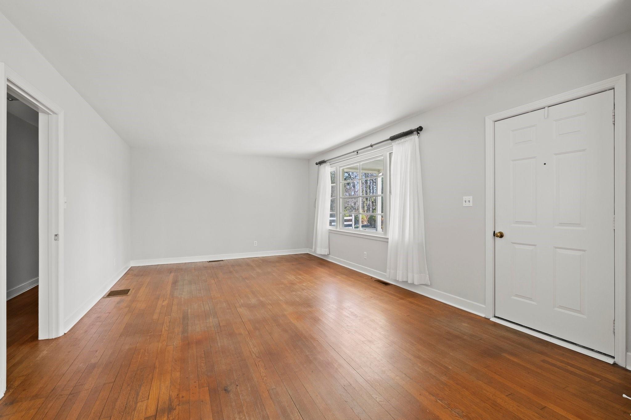 480 Loop Road Hendersonville, NC 28792 - Photo 3 of 26 an empty room with wooden floor closet and windows