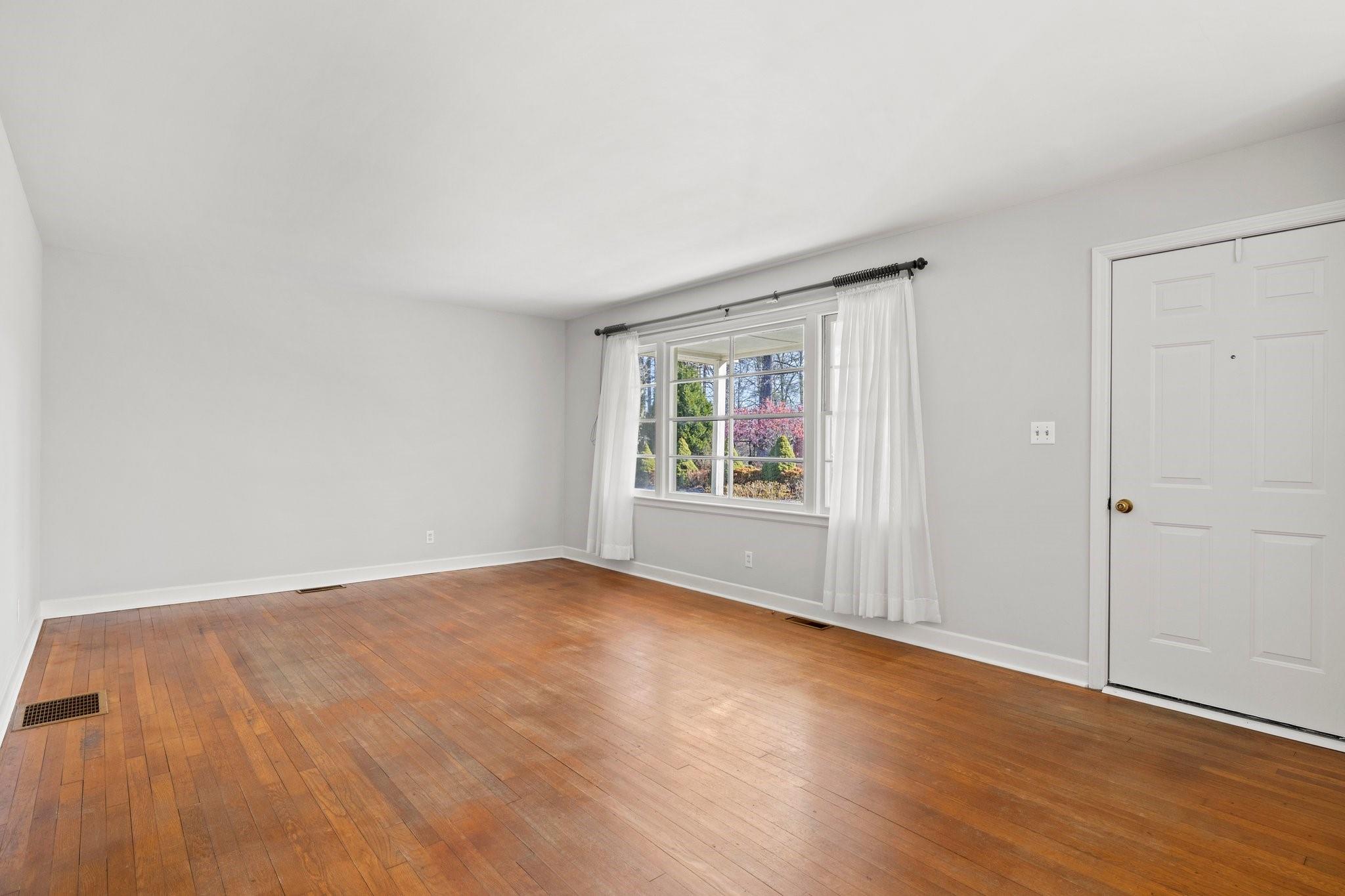 480 Loop Road Hendersonville, NC 28792 - Photo 4 of 26 an empty room with wooden floor and windows