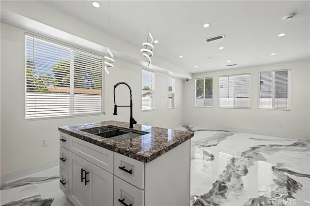 a kitchen with granite countertop cabinets a sink and appliances