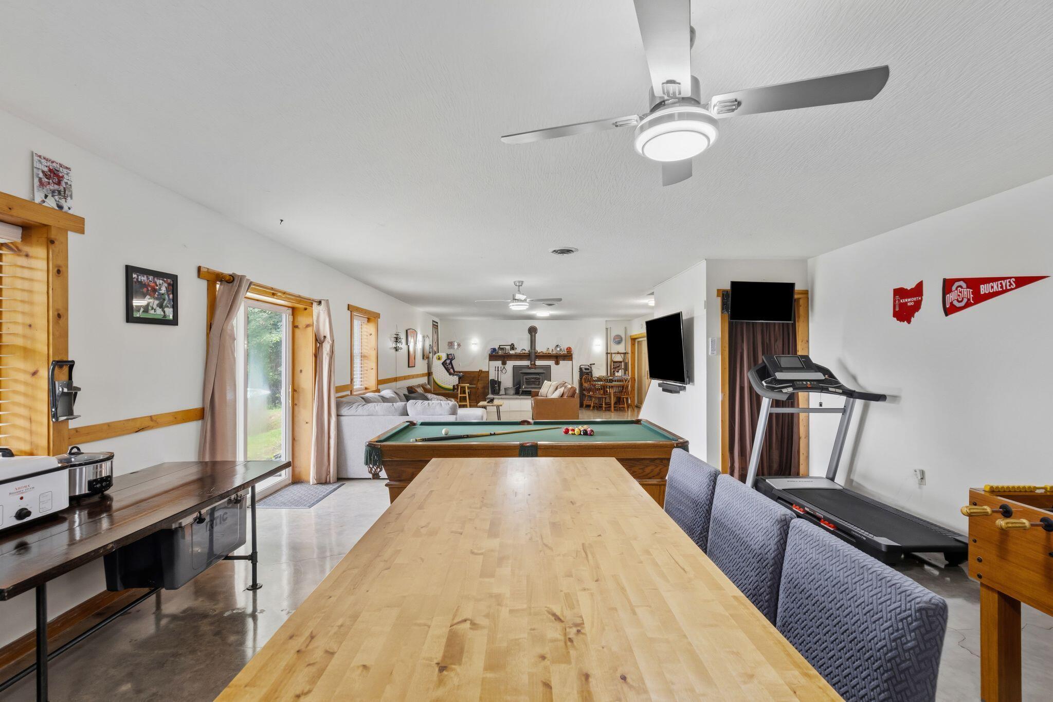 10446 Rich Hollow Road Southwest Lancaster, OH 43130 - Photo 12 of 83 Spacious recreation room featuring light wood flooring, a ceiling fan with integrated lighting, and multiple windows with wood trim