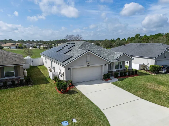 an aerial view of multiple houses with a yard