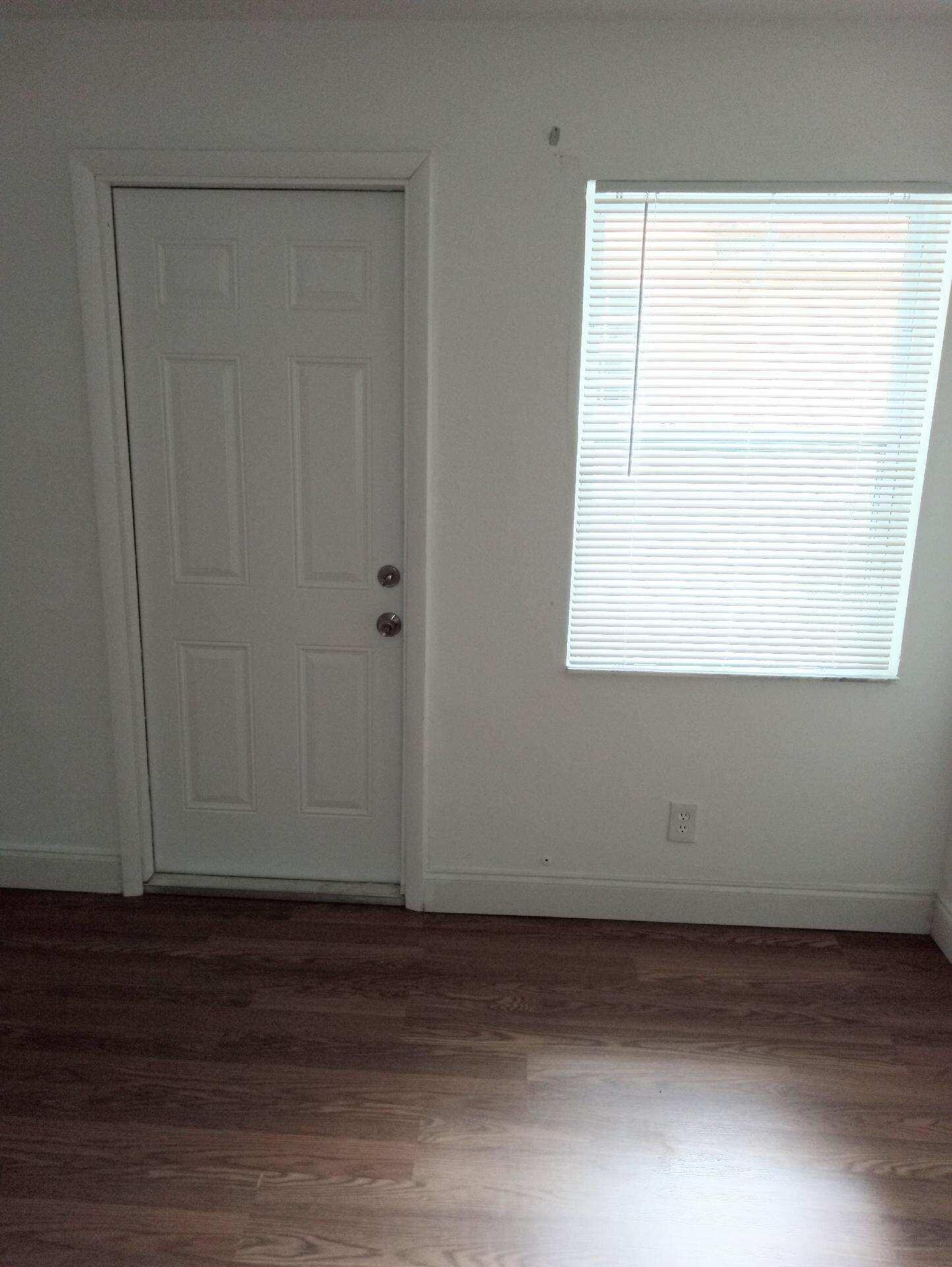 305 Northwest 4th Avenue Delray Beach, FL 33444 - Photo 16 of 45 a view of an empty room with wooden floor and a window