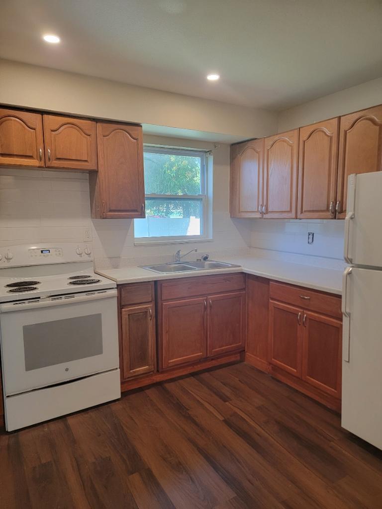 305 Northwest 4th Avenue Delray Beach, FL 33444 - Photo 21 of 45 a kitchen with granite countertop wooden floors and white stainless steel appliances