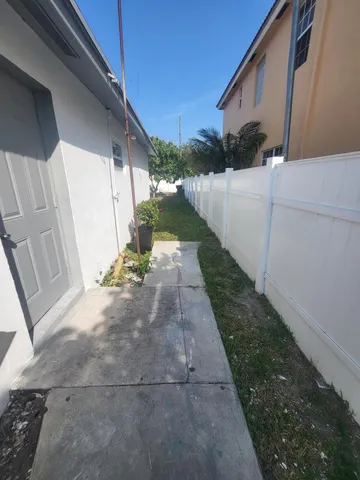 a view of a pathway of a house with wooden fence