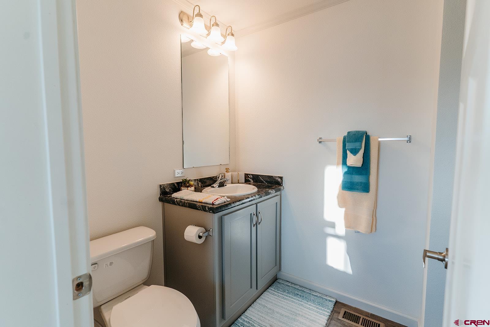 62650 Lasalle Road, Unit 325 Montrose, CO 81403 - Photo 17 of 24 a bathroom with a granite countertop toilet sink and mirror