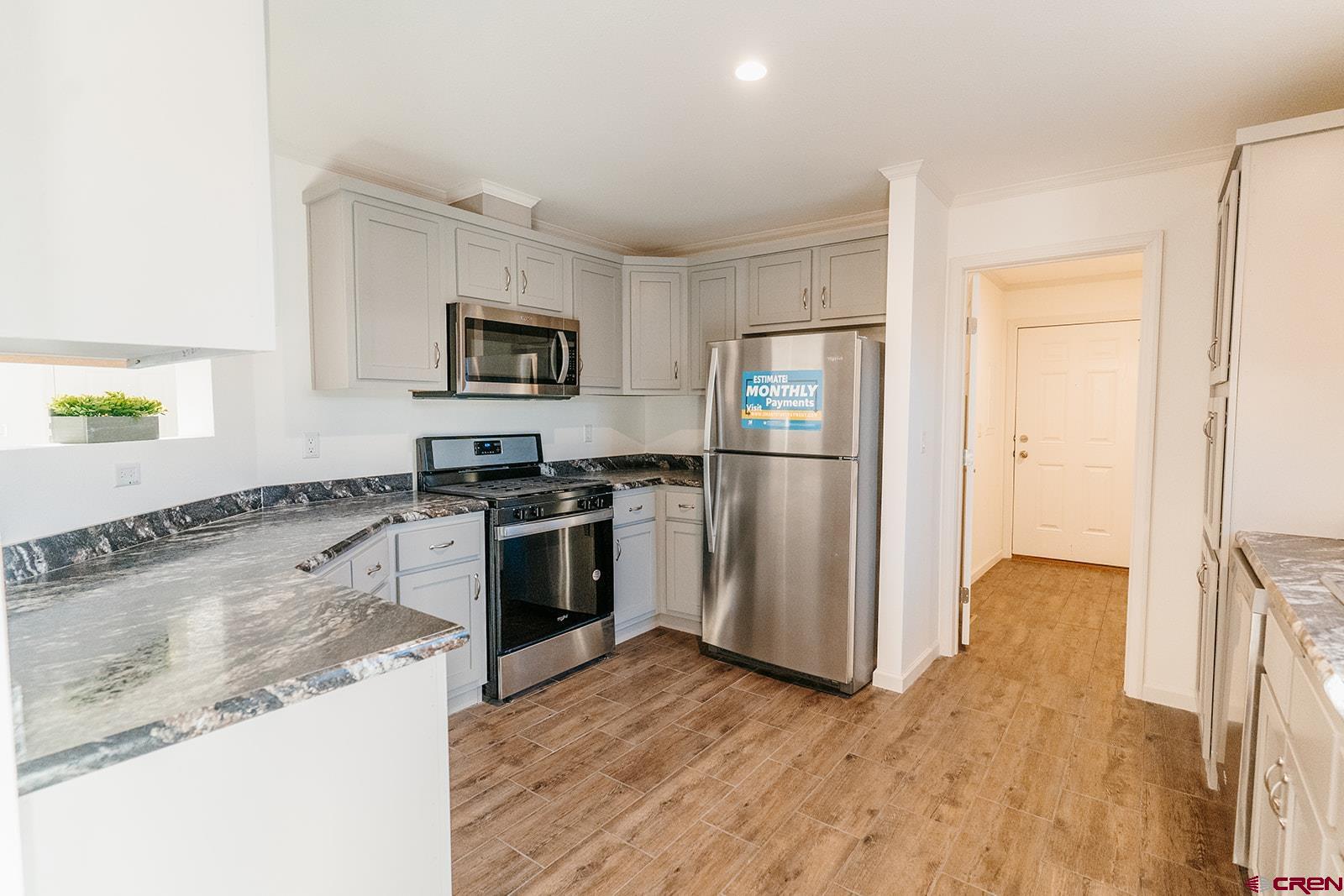 62650 Lasalle Road, Unit 325 Montrose, CO 81403 - Photo 7 of 24 a kitchen with granite countertop a refrigerator and a stove top oven