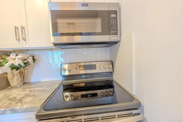 a stove top oven sitting inside of a kitchen