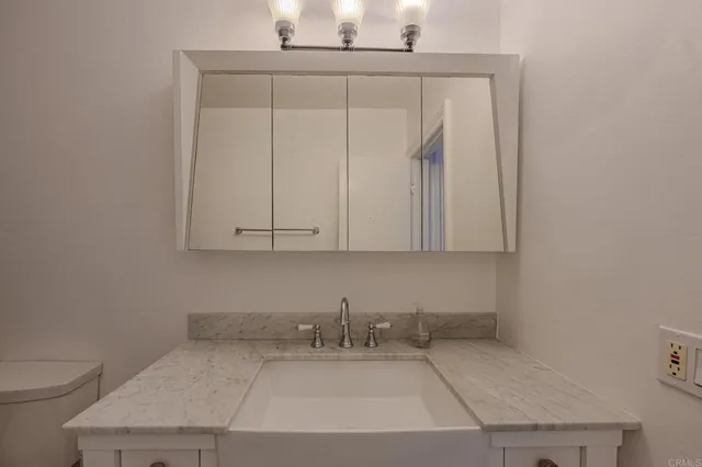 a bathroom with a sink a toilet and vanity