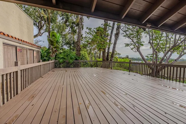 a balcony with wooden floor table and chairs