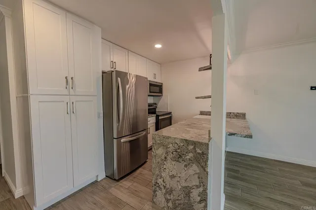 a view of a refrigerator in kitchen and wooden floor